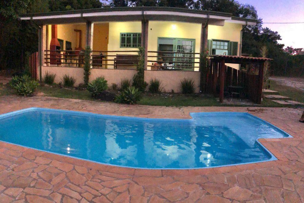 une petite piscine bleue en face d'une maison dans l'établissement Hospedagem em meio a natureza!, à Águas da Prata
