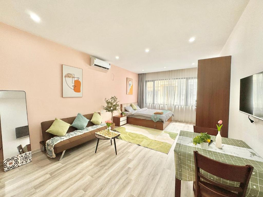 a living room with a couch and a bed at The Little Home - Cù Chính Lan - Modern & Comfy Apartment in Hanoi