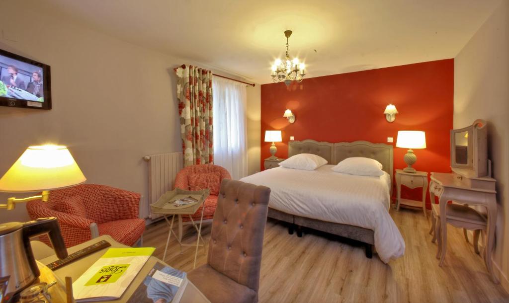 um quarto com uma cama e uma sala de estar em LOGIS Auberge DE LA TRUFFE em Sorges