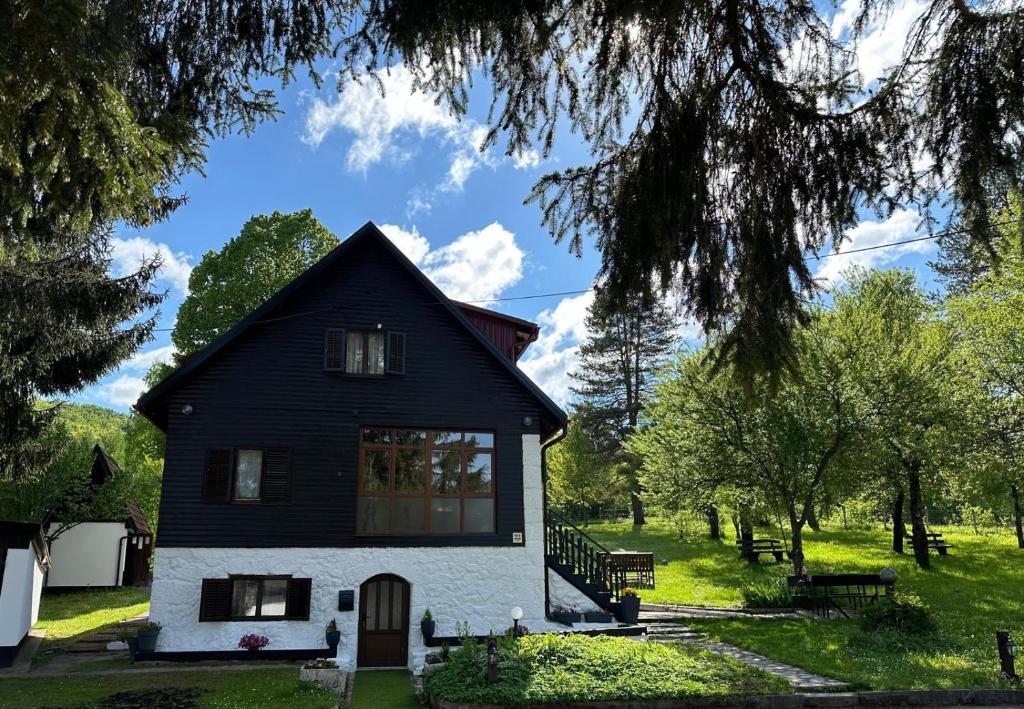a black and white house in a green field at Guest house Zeder in Jezerce