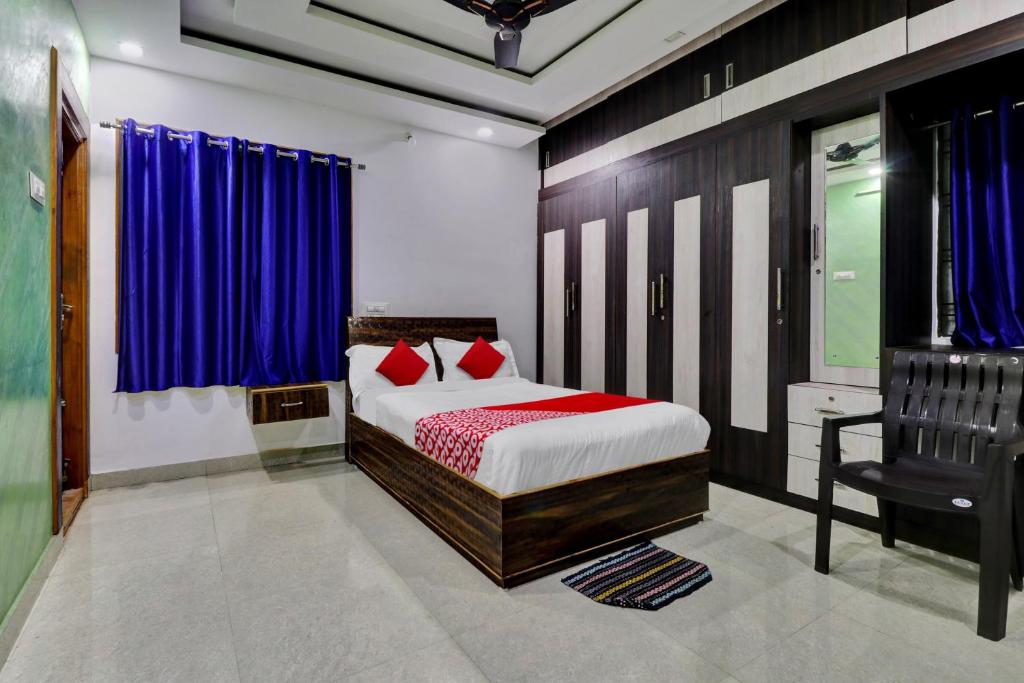 a bedroom with a bed and a chair in it at Seshadri Homestay in Tirupati