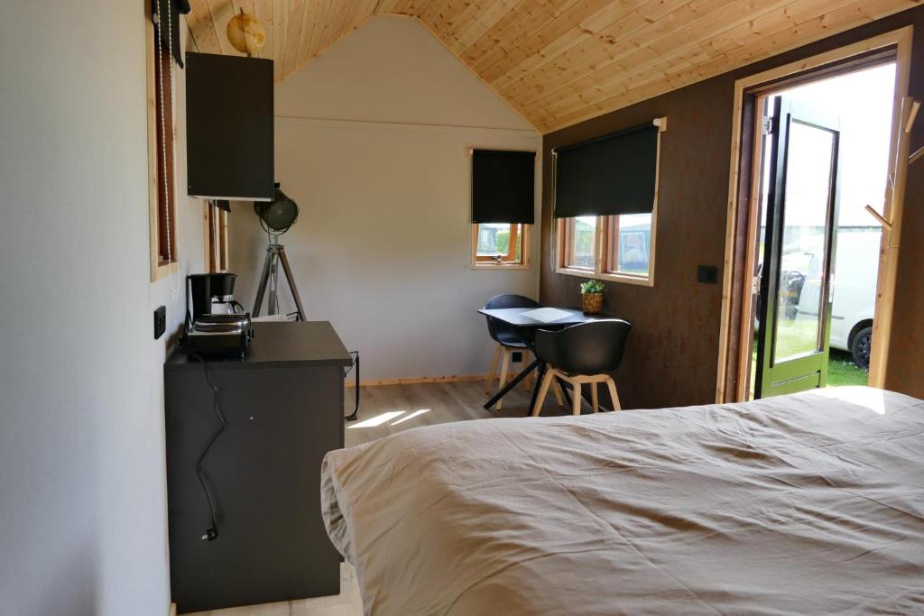 1 dormitorio con cama, escritorio y mesa en Tinyhouse Giethoorn en Giethoorn