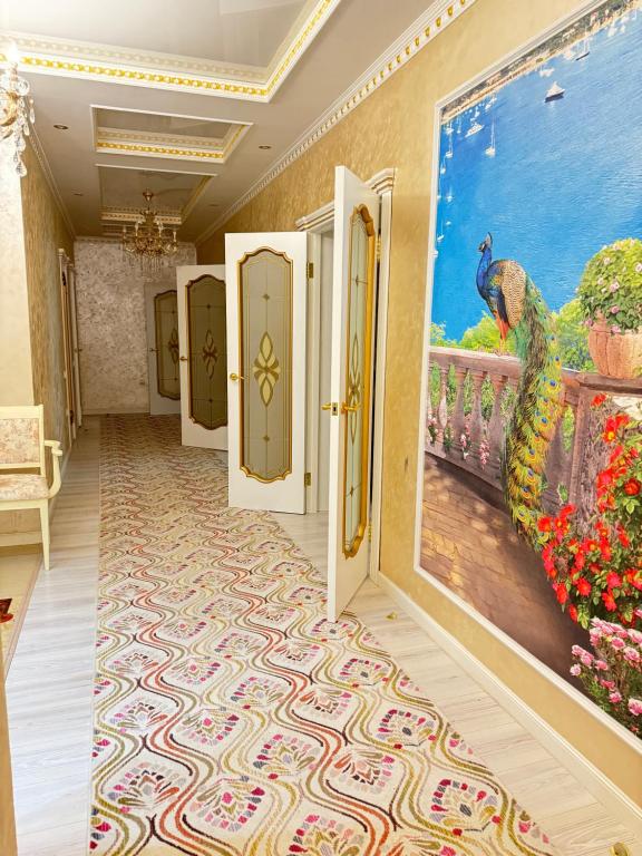 un couloir avec des portes et une peinture d'un paon dans l'établissement Люкс апартаменты в Актобе, à Aqtöbe