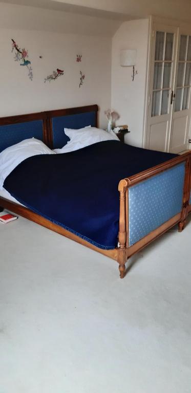 Ce lit se trouve dans une chambre dotée d'une couverture bleue. dans l'établissement les ormeaux, à Ambleteuse