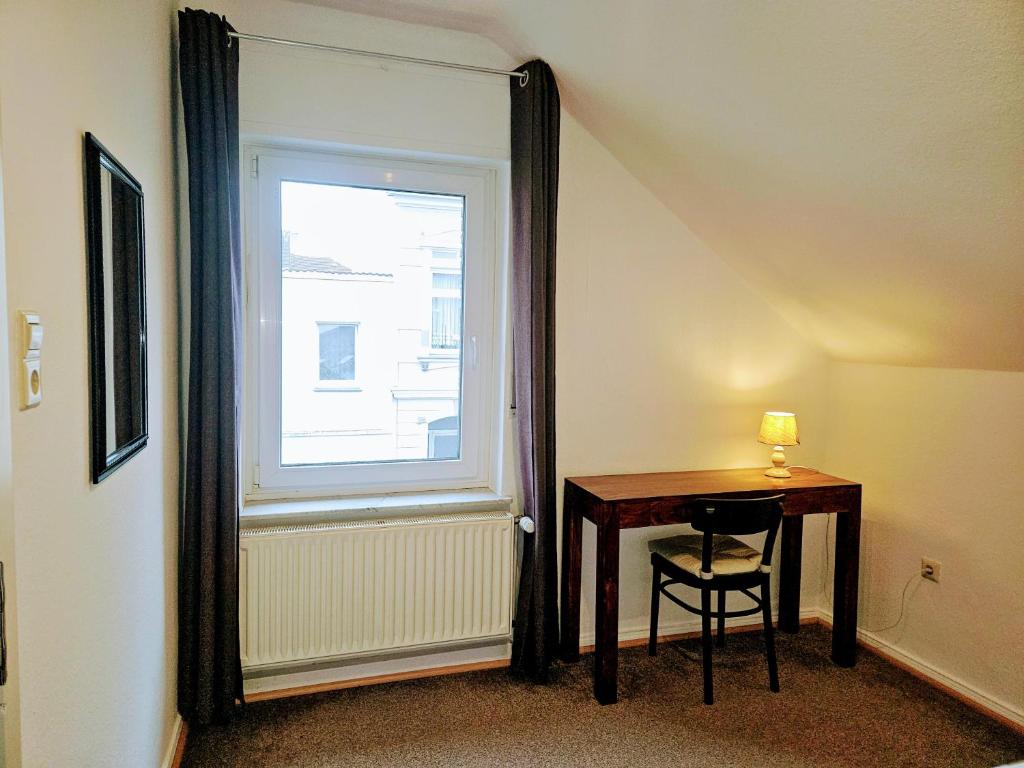 a room with a table and a window with a mirror at Apartment Jackie 2 in Bielefeld