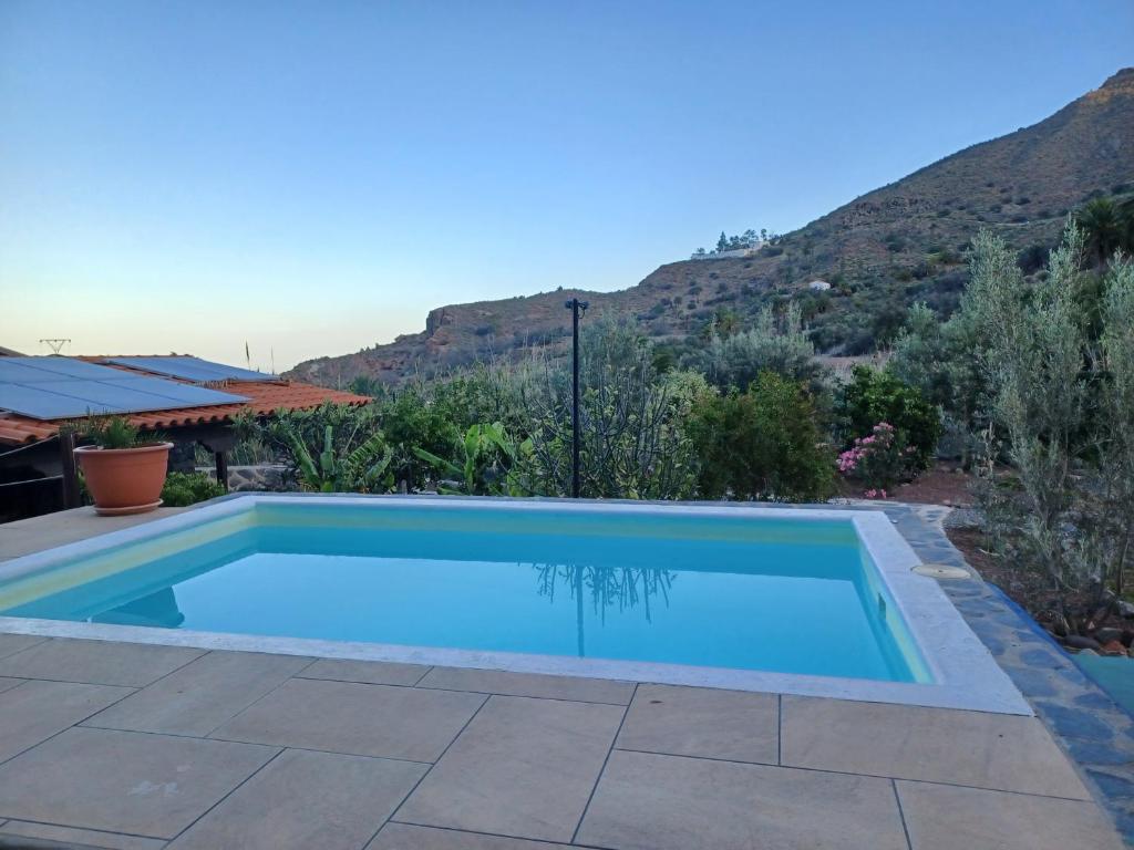 una piscina con una montagna sullo sfondo di Las Palmeras Temisas a Temisas