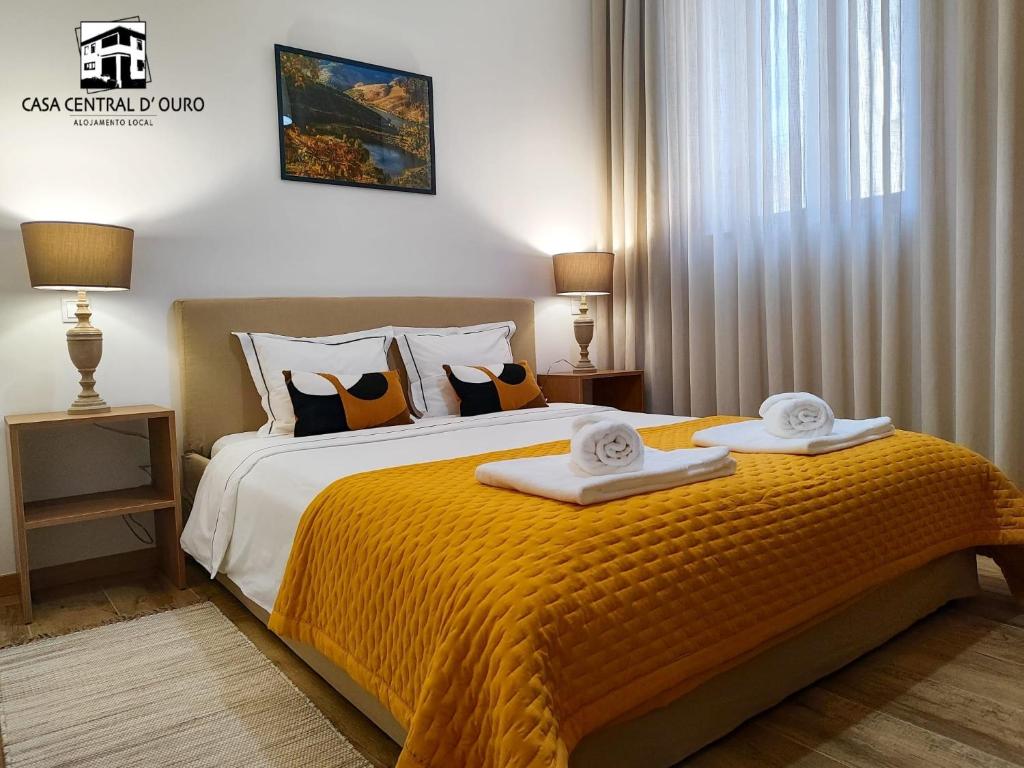 una camera da letto con un letto e due asciugamani di Casa Central D'ouro a Tabuaço