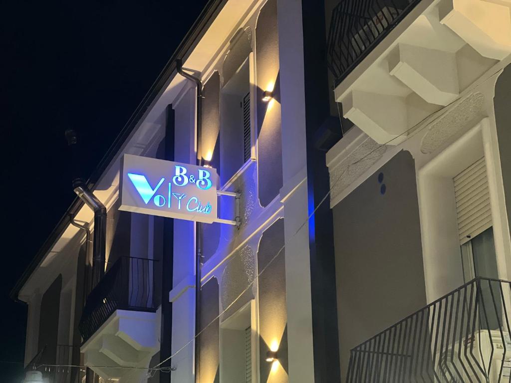 znak na boku budynku w nocy w obiekcie B&B Volì Club w mieście Siderno Marina