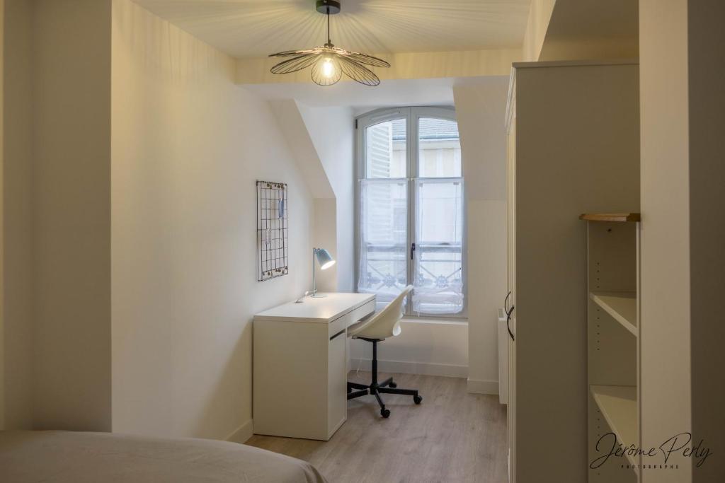 1 dormitorio con escritorio, ventana y cama en Lémaliv, en Orléans