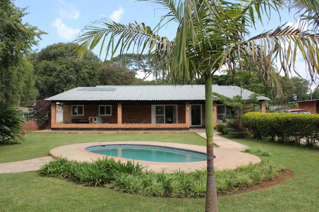 a house with a palm tree in front of it at Spacious 3 bedroom house in Lilayi, Lusaka in Lusaka