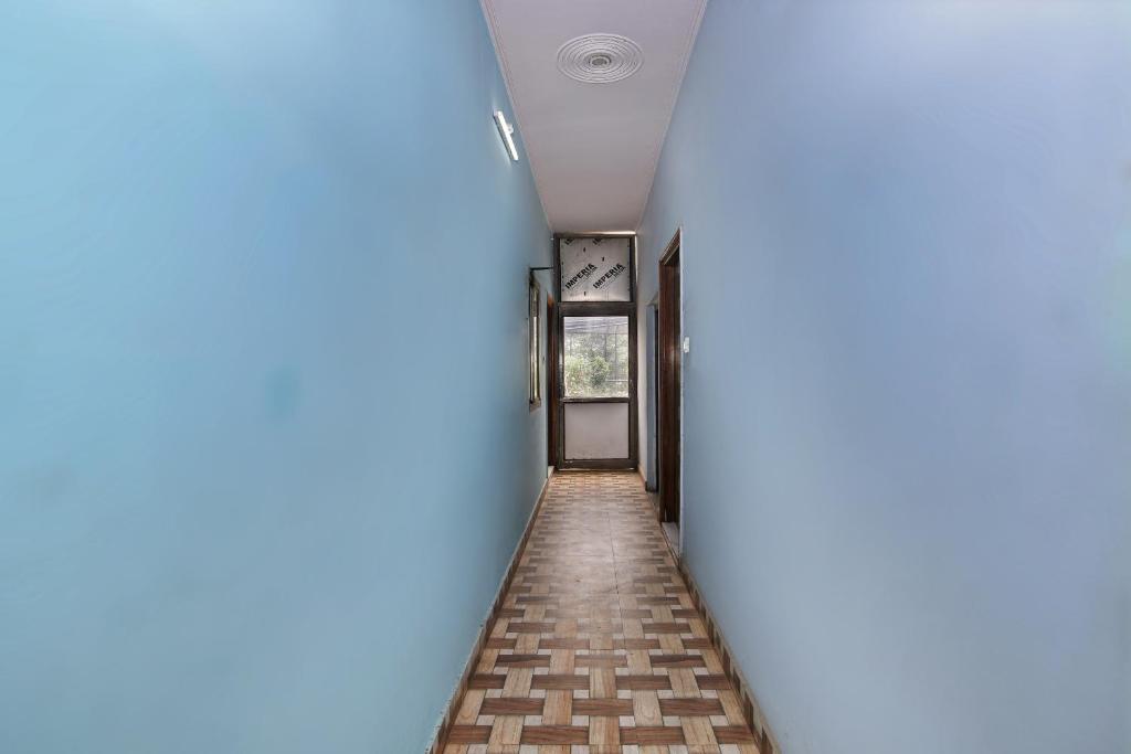 un pasillo vacío con paredes azules y suelo de ladrillo en Super OYO Hotel Haveli Inn1 en Varanasi
