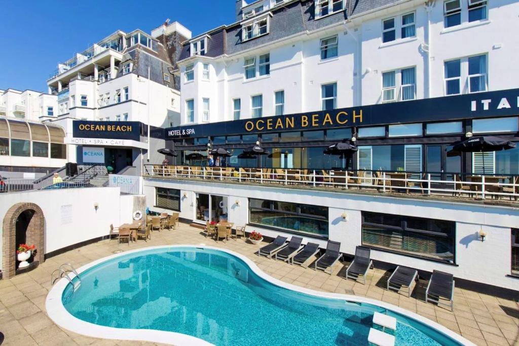 a hotel with a swimming pool in front of a building at Ocean Beach Hotel & Spa - OCEANA COLLECTION in Bournemouth