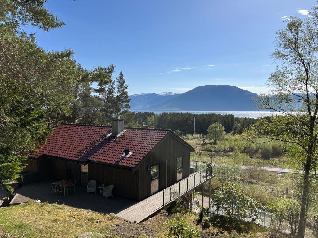 a house with a deck and mountains in the background at Bosdalhuset in Lavik