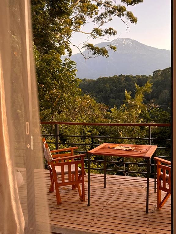 a table and chairs on a deck with a view at Kaliwa Lodge in Moshi