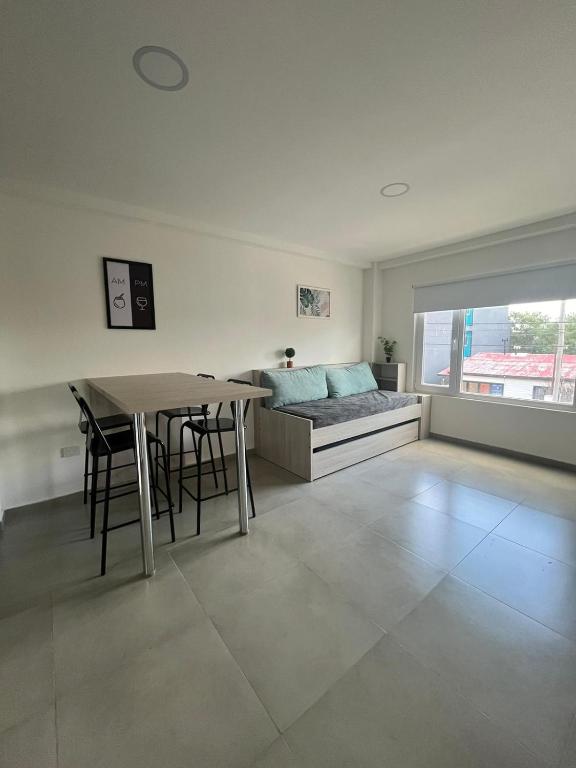 a living room with a bed and a table with chairs at Apart Goleta Florencia in Ushuaia