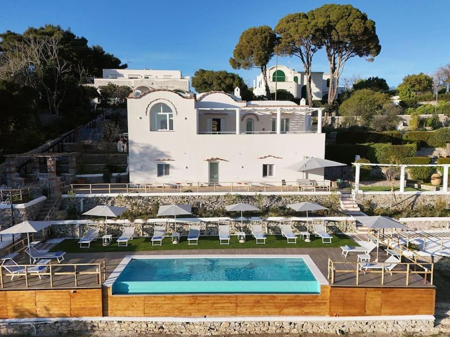eine Villa mit einem Pool vor einem Haus in der Unterkunft Elegant Villa in Anacapri Infinity Pool & Design in Anacapri