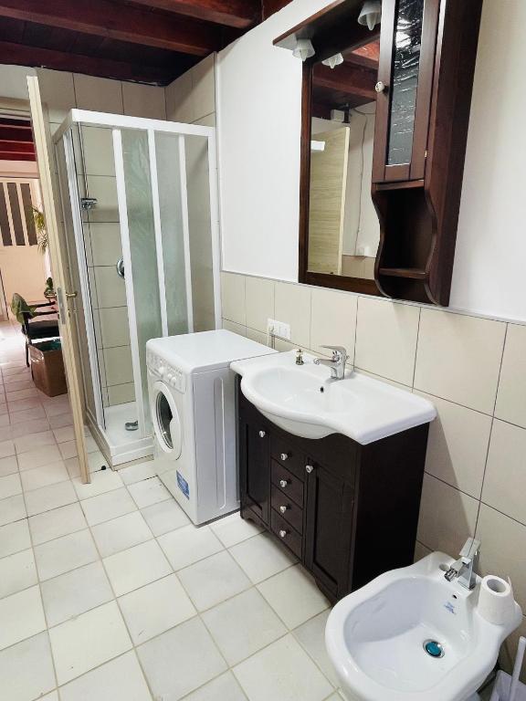 uma casa de banho com uma máquina de lavar roupa e um lavatório em Arobba em Villaggio Mosè