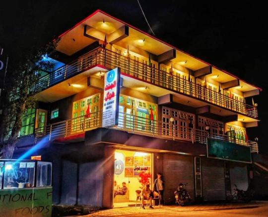 budynek z ludźmi stojącymi przed nim w nocy w obiekcie Al Jannat Hotel & Relax Inn Guest House Skardu w mieście Skardu