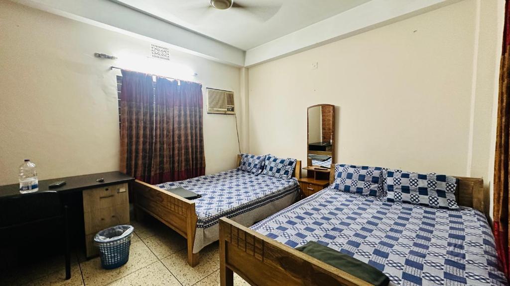 1 dormitorio con 2 camas, tocador y escritorio en Hotel Image Residential Near Square Hospital, en Dhaka