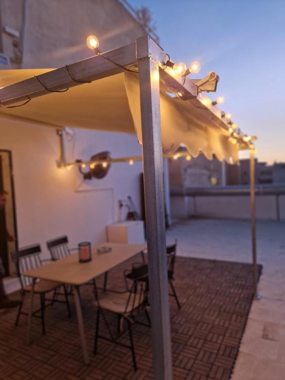 - une table et des chaises sous un parasol sur la terrasse dans l'établissement Ermou studio apartment, à Athènes