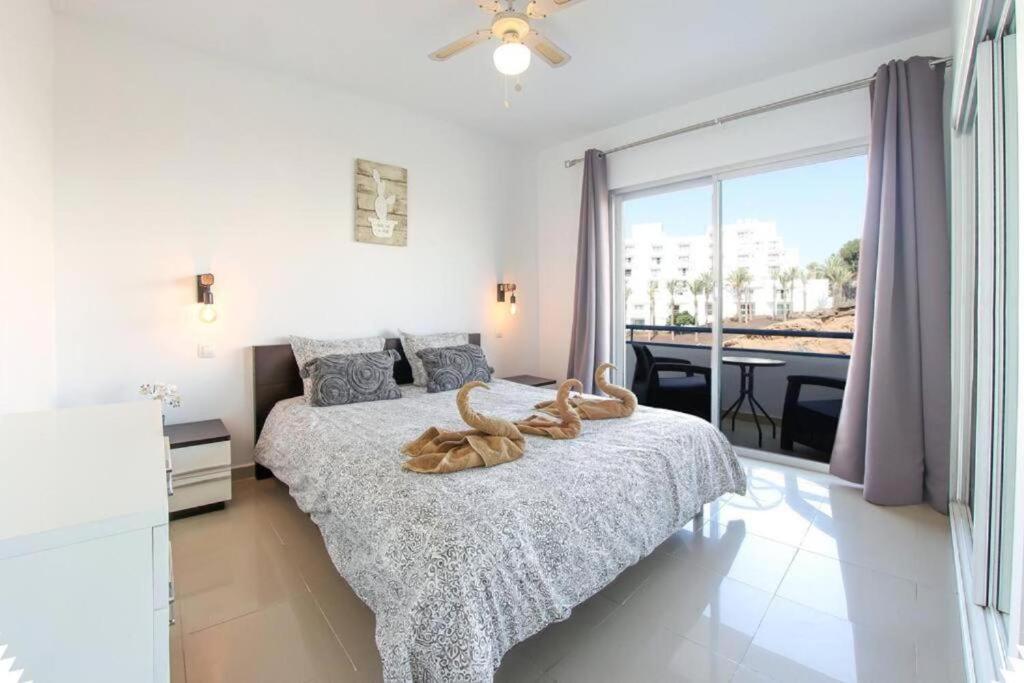 a bedroom with two beds and a large window at Amazing 2 bedroom flat with Beachfront and Pool, Paraíso del Sur A306 in Playa Paraiso