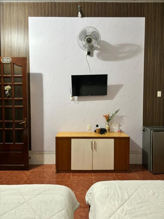 Cette chambre comprend 2 lits et une télévision murale. dans l'établissement Đức Long, à Vung Tau