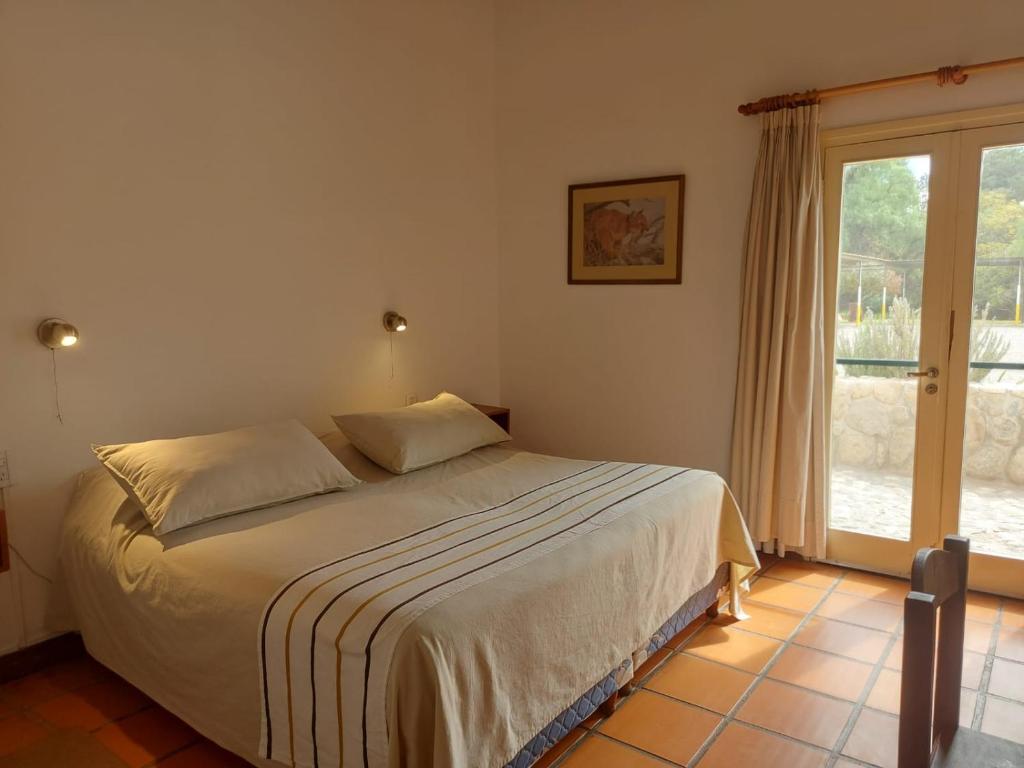 a bedroom with a bed and a large window at Hosteria Automovil Club Argentino Cachi in Cachí