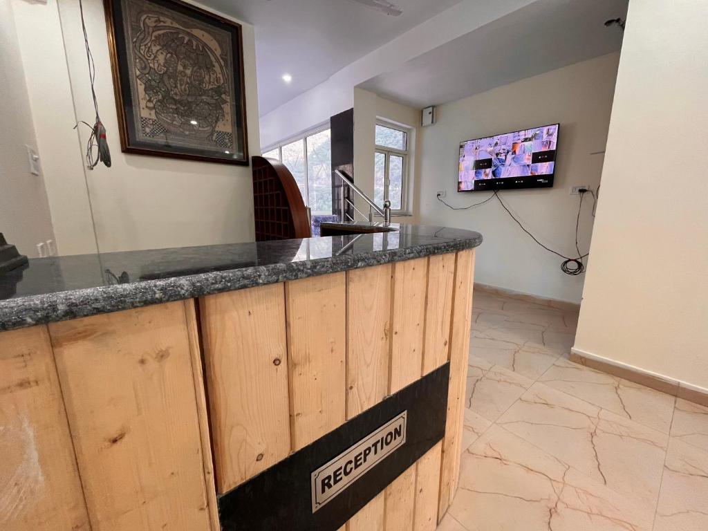 a kitchen with a counter with a sink and a tv at Samantha Guest House in Bhavnagar