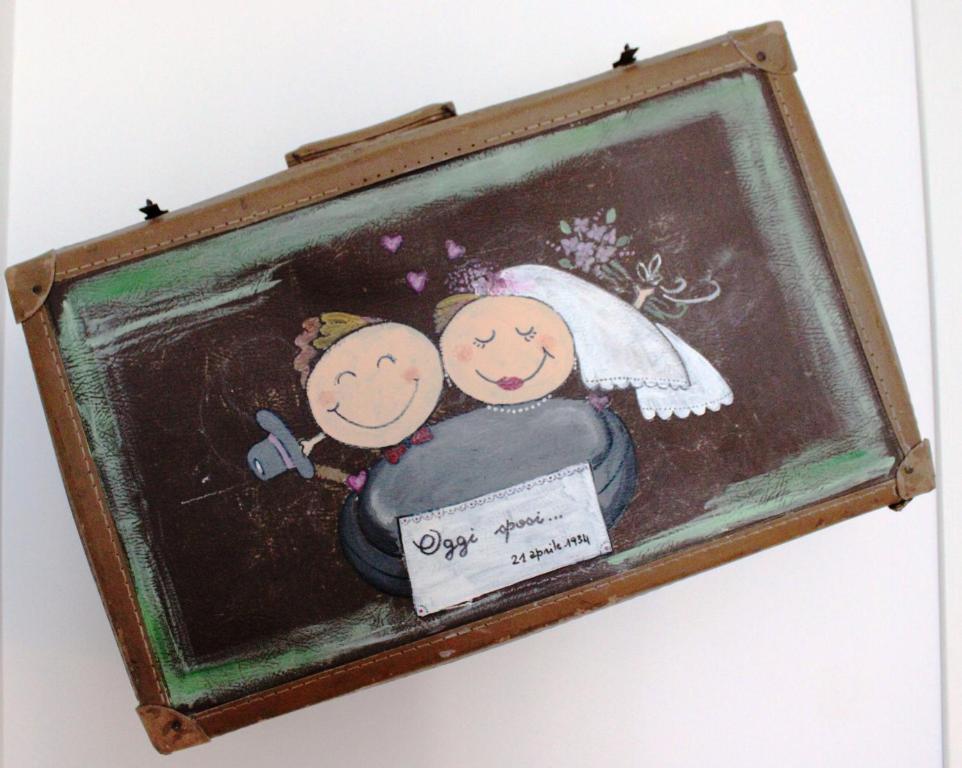 an old suitcase with a picture of a bride and groom at B&B Casa del Faro SanVallero Adults Only in Portopalo