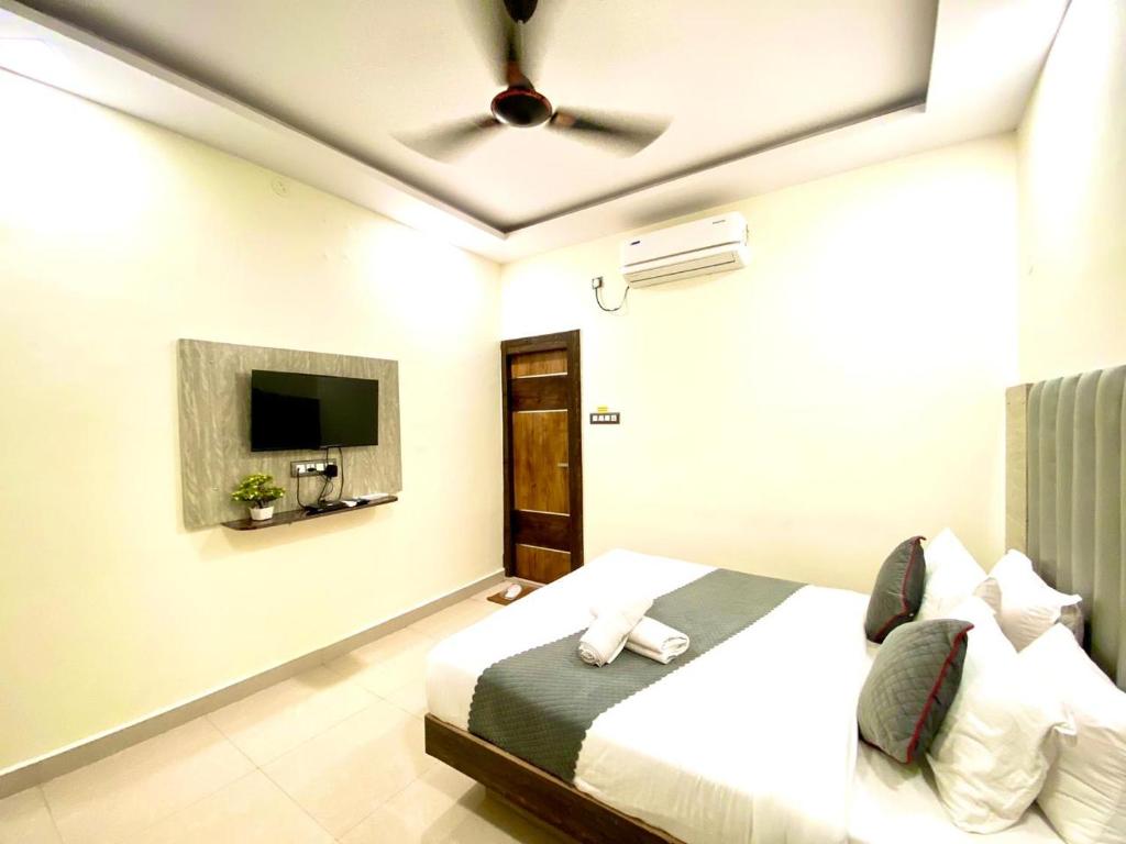 Hotel Sky International- Airport Zone Hyderabad في شامشاباد: غرفة نوم بسرير وتلفزيون بشاشة مسطحة