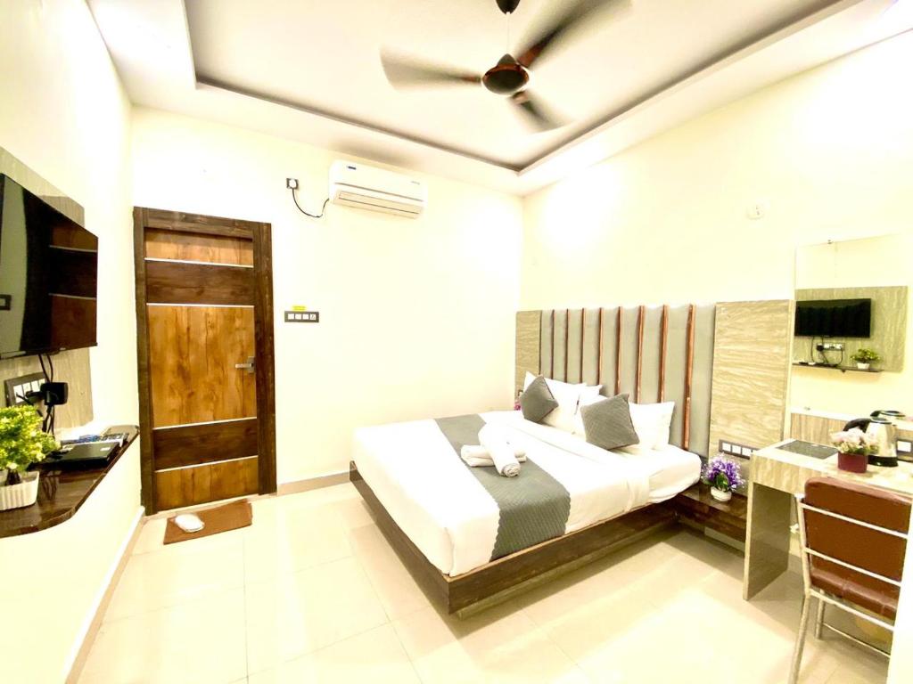 Hotel Sky International- Airport Zone Hyderabad في شامشاباد: غرفة نوم مع سرير ومروحة سقف