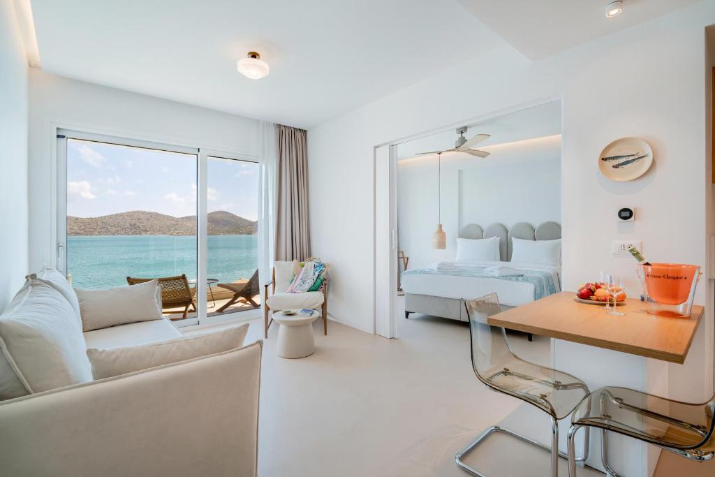 a hotel room with a view of the ocean at Ocean Rythm Elounda Suite in Elounda