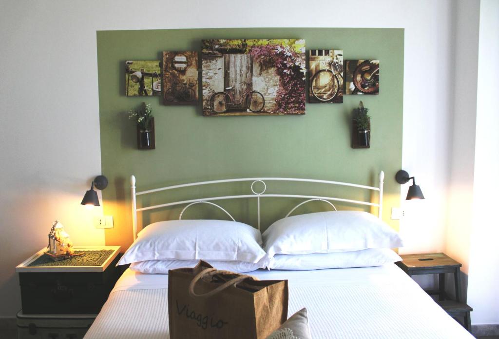 1 dormitorio con 1 cama blanca y 3 cuadros en la pared en B&B Casa del Faro SanVallero Adults Only, en Portopalo di Capo Passero