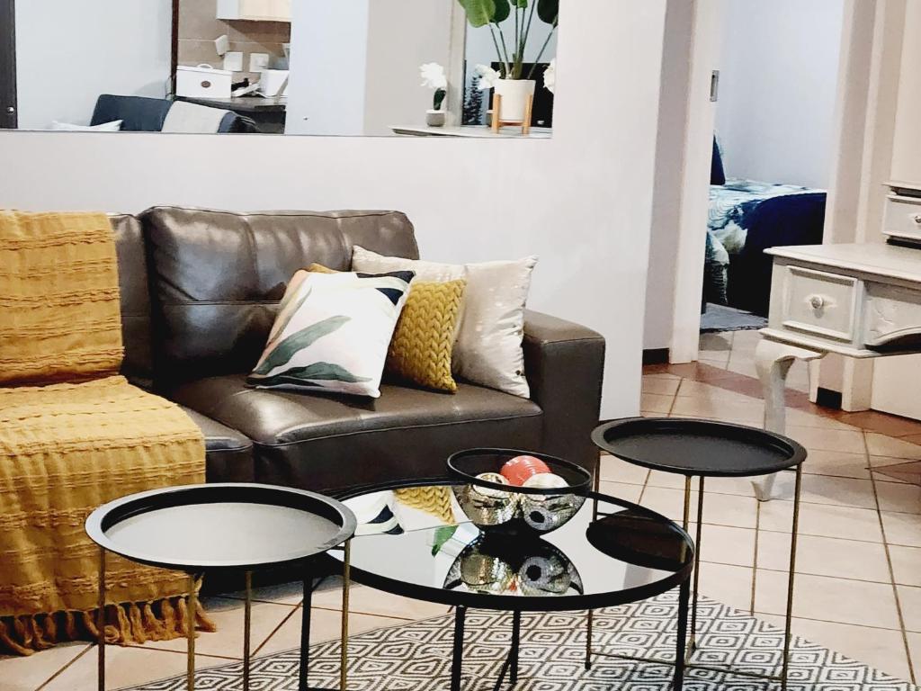 a living room with two tables and a couch at Lemon tree in Pretoria