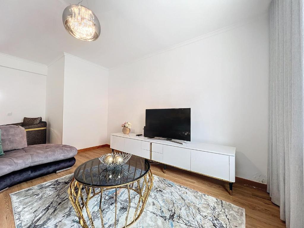 a living room with a tv and a couch at Moradia Uriel in Santa Cruz