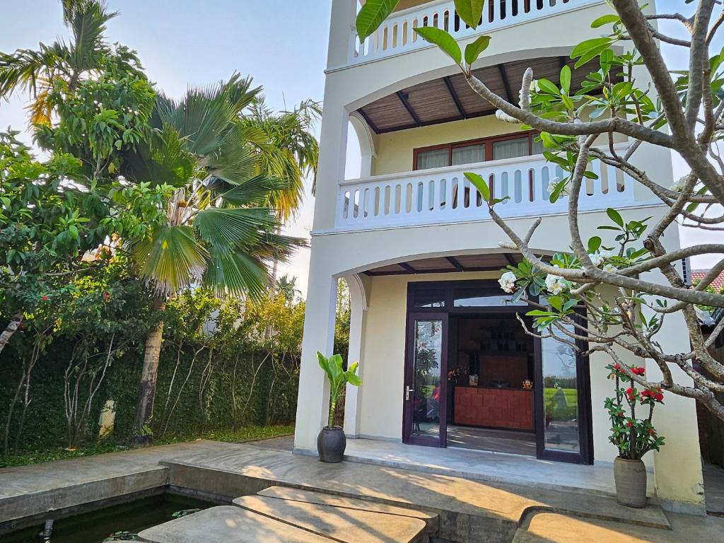 En Retreat Villa Hoi An في Hiếu Nhơn: بيت ابيض وامامه مسبح