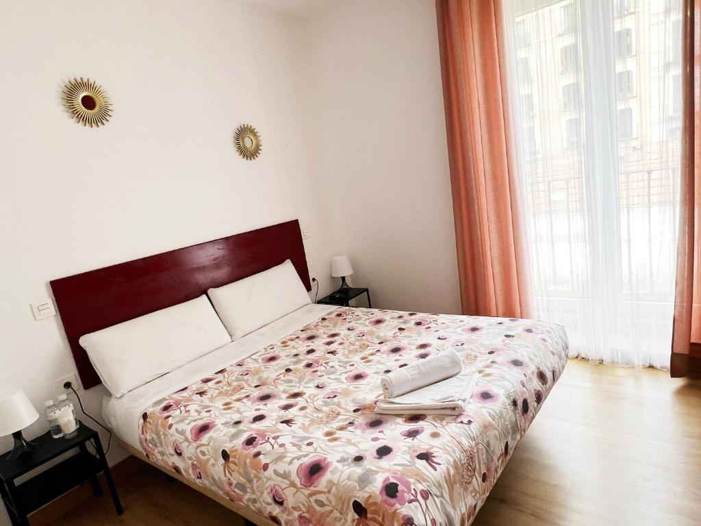 Un dormitorio con una cama con un teléfono. en Hostal Abaaly, en Madrid