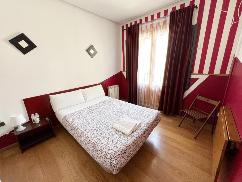 マドリードにあるオスタル ラ カサデ ラ プラサの小さなベッドルーム(ベッド1台、椅子付)