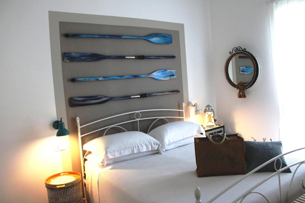 a bedroom with a bed with blue shovels on the wall at B&B Casa del Faro SanVallero Adults Only in Portopalo