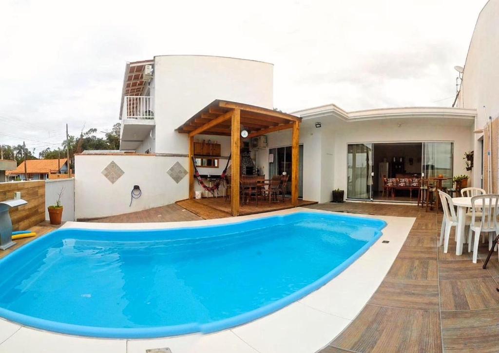 uma villa com piscina em frente a uma casa em Suítes Moreira em Penha