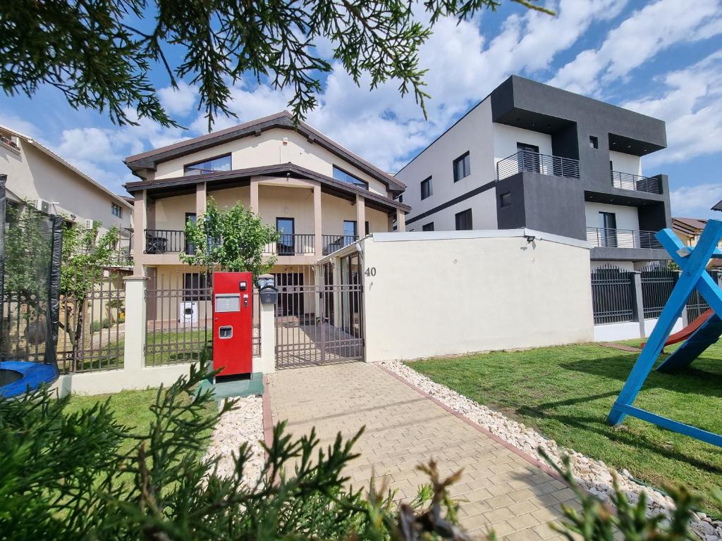 uma casa com uma caixa de correio vermelha em frente em Vila duMio em Eforie Nord