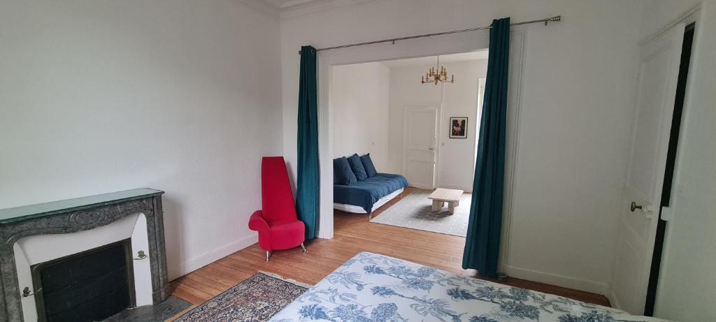 een woonkamer met een blauwe bank en een rode stoel bij Le Balcon d'Anatole in Le Mans