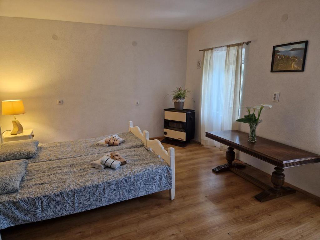 sypialnia z łóżkiem, stołem i oknem w obiekcie Stan na dan Dunja w mieście Herceg Novi