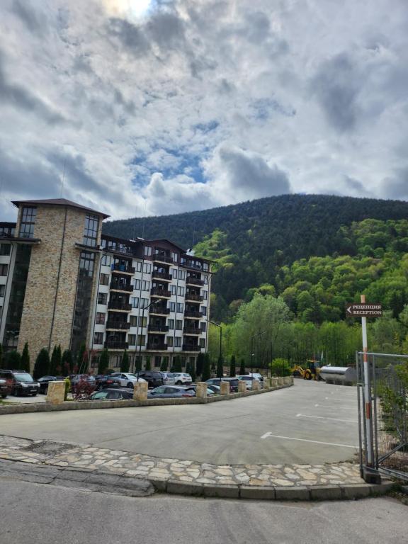 a parking lot with a building and a mountain at St Spas in Velingrad