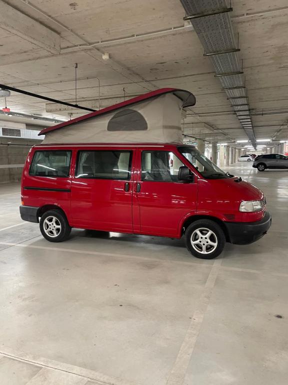 una furgoneta roja estacionada en un garaje en Camper car in underground parking en Barcelona
