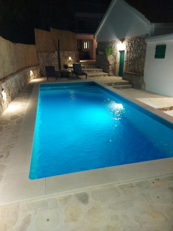 ein Pool in der Nacht mit blauem Wasser in der Unterkunft Didovi dvori in Seline
