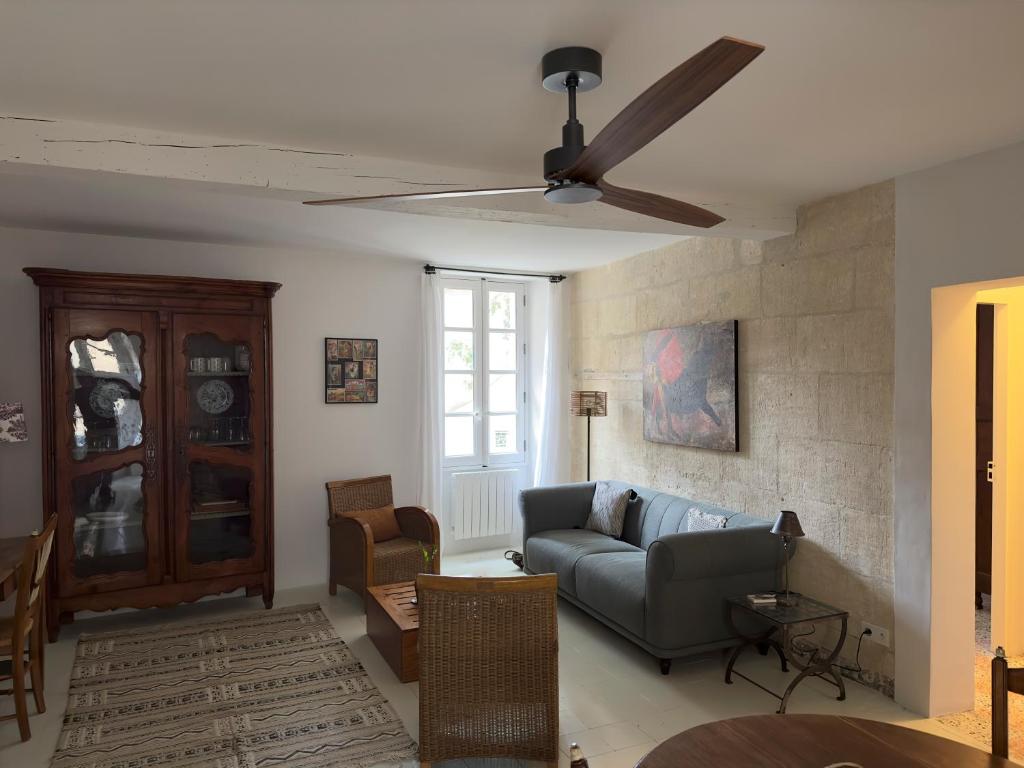 ein Wohnzimmer mit einer Couch und einem Deckenventilator in der Unterkunft Cœur d'Arles in Arles