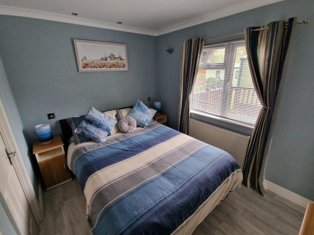 1 dormitorio con 1 cama grande y ventana en Windermere lodge,sleeps 6 en Windermere