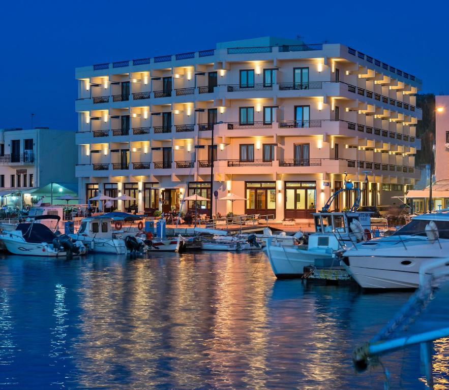 a building with boats docked in front of a marina at Porto Veneziano Hotel in Chania