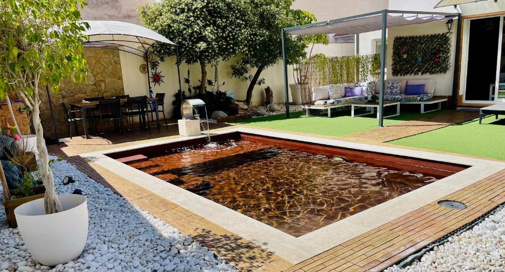 a pond in the middle of a yard with a patio at Villa Paradise, urban oasis by -Toprentalsbarcelona- in Esplugues de Llobregat